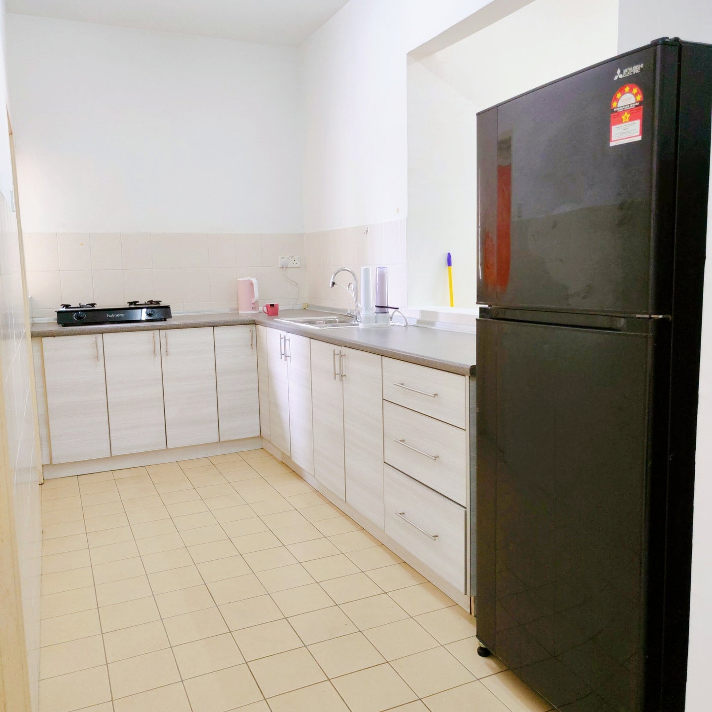 Kitchen area with a fridge inside a house for rent at Aman Heights Seri Kembangan